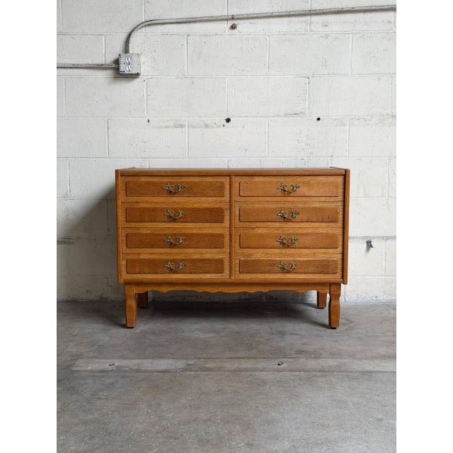 This vintage Danish wooden dresser features an eight-drawer configuration arranged in a dual-column layout. The classic...