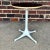 This is a mid century George Nelson for Herman Miller tulip side table. It has an off-white metal pedestal base with a...