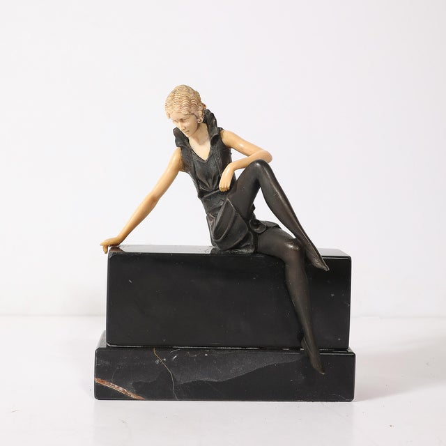 This Art Deco flapper sculpture, crafted in bronze and resin, epitomizes the bold elegance of the 1930s French aesthetic....
