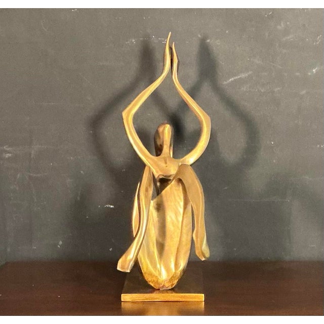 Large brass modernist sculpture of a stylized nude female in a yoga or dancing pose with her hands pointed up, mounted...