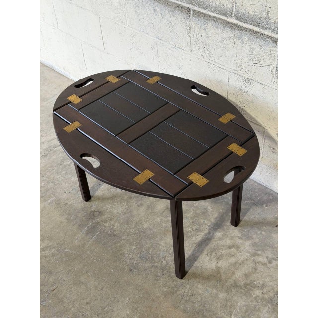 This adaptable butler table features a smart design with hinged, drop-down sides and cutout handles. The classic...