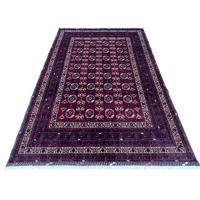 Afghan Turkmen Waziri rug, hand knotted in Afghanistan from 100% wool. Measuring 6’8” x 9’9”, this rug features a rich...