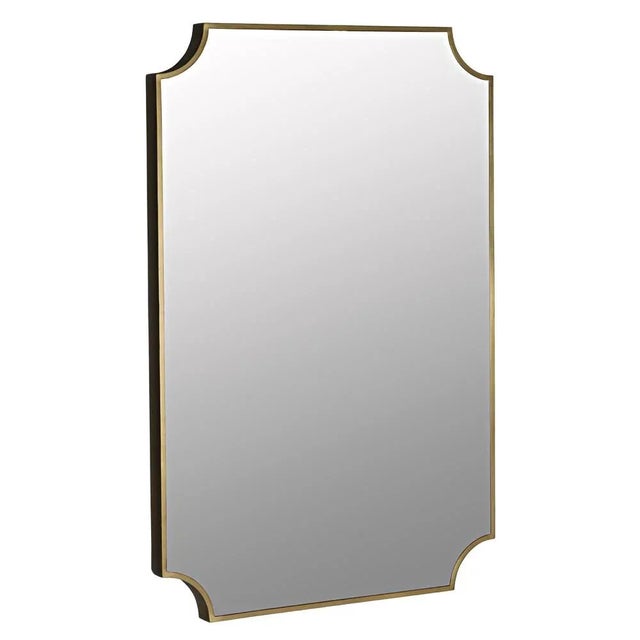 A slim band of metal surrounds this polished wall mirror. The burnished antique brass finish of the frame warms the look...