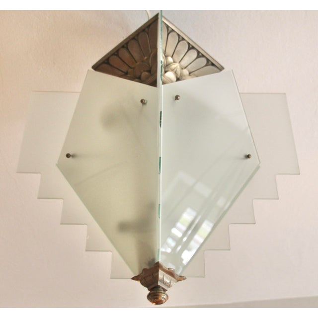 This Art Deco ceiling light, crafted from nickel-plated bronze and featuring eight frosted glass panels, perfectly...
