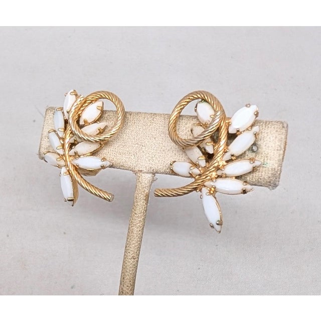 Goldtone prong set marquise white rhinestones leaves with curled "stem" at the top clip back earrings. Marked "Napier Pat....