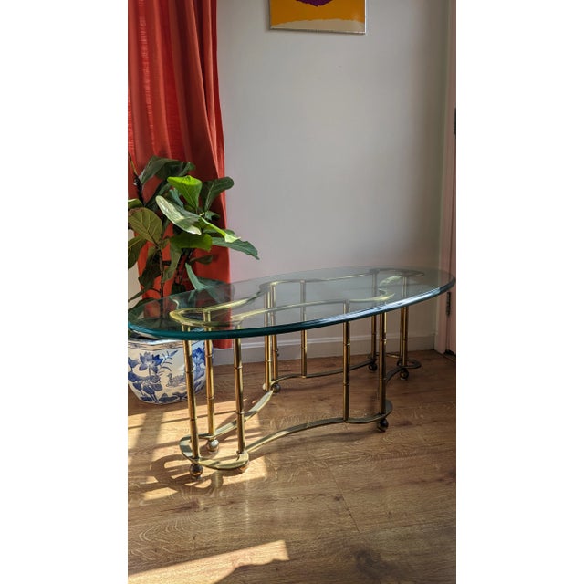 Beautiful brass and glass cocktail table and while no makers mark or label is present it's likely to be Mastercraft, c...