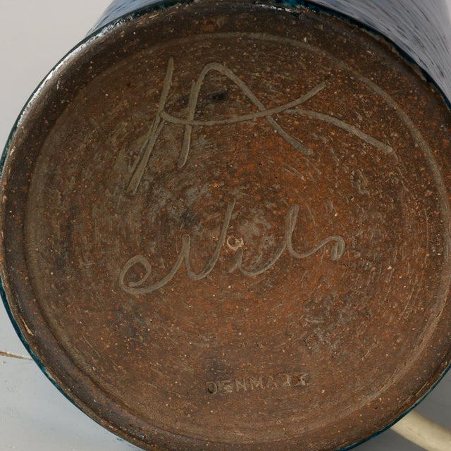 Table lamp made of partly blue-glazed stoneware with relief pattern. Signed “HA Nils Denmark” on the bottom. Signature...