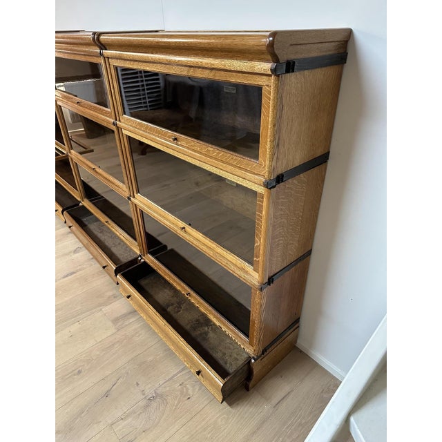 Antique oak Globe Wernicke bookcase in a wide, low configuration. The unit is constructed entirely from modular sections,...