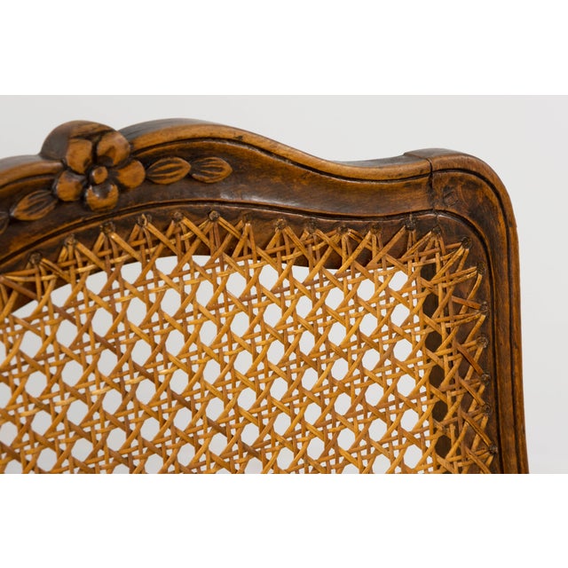 A refined and well-proportioned set of twelve early 20th century French Provincial dining chairs, executed in the Louis XV...