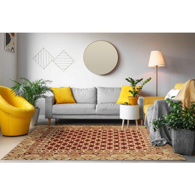 This hand knotted wool rug features a primary color palette of coral, salmon, and pink tones. Produced in India, this...