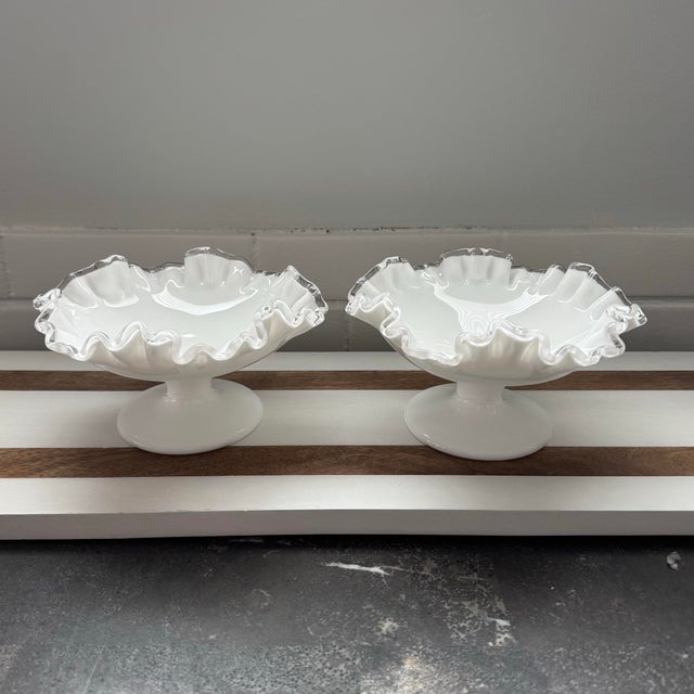 A pair of vintage Fenton Silver Crest milk glass compotes or candy dishes featuring a distinctive ruffled edge with a...