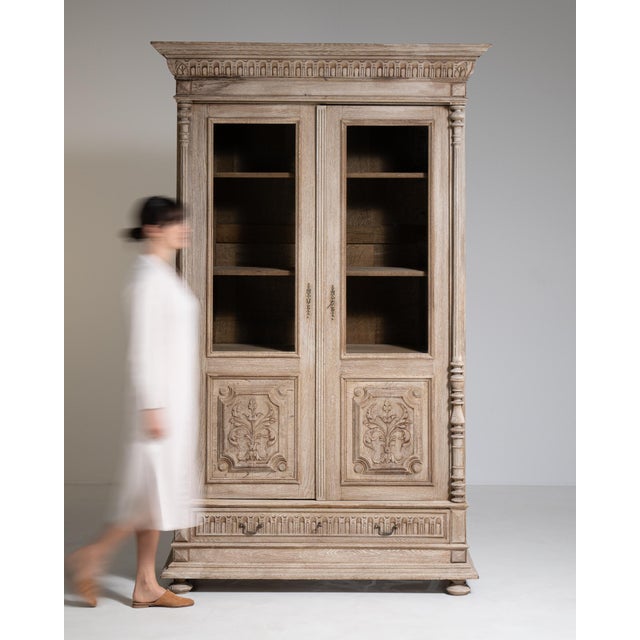 A decorative vitrine featuring carved details that emphasize craftsmanship and style. The structure balances storage and...
