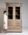 A decorative vitrine featuring carved details that emphasize craftsmanship and style. The structure balances storage and...