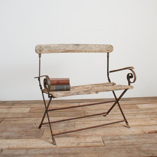 A charming nineteenth century French garden bench. The bench has an iron frame with riveted joints and teak wood slat...