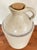 Antique late 1800s American stoneware jug. It is a light sand or beige color with brown accenting. There is an impressed...