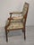 Antique Louis XVI-style armchair from France, with a wooden frame and floral upholstery. Simple, elegant design with...