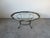 Elegant vintage coffee table featuring a sculptural brass base with stylized claw feet and a beautifully shaped scalloped...