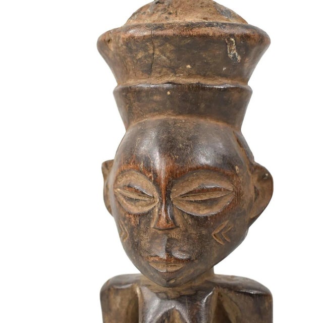 The Luba female figure is crafted as a veneration of feminine beauty and motherhood. Crafted from wood, the Luba female...