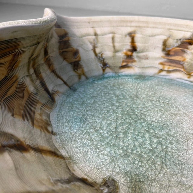 Monumental Japanese mid-century bowl with a powerful, organic form. The rim is subtly indented on one side, breaking the...