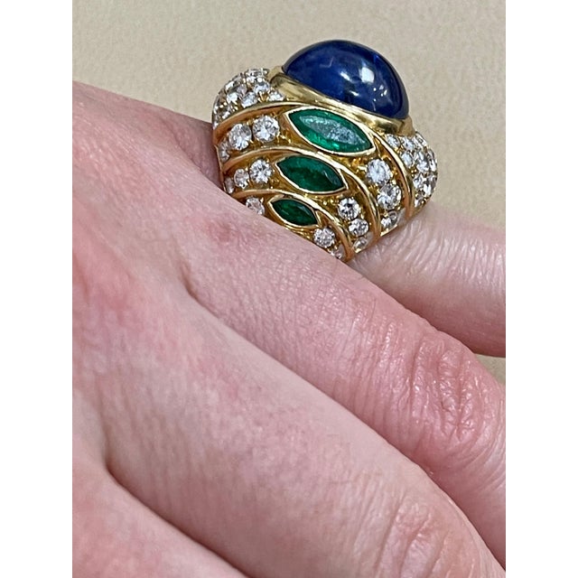 18 Carat Blue Sapphire Cabochon natural Diamonds 4.5 ct of brilliant Round cut diamonds. 3 Marquise shape Emeralds on each...
