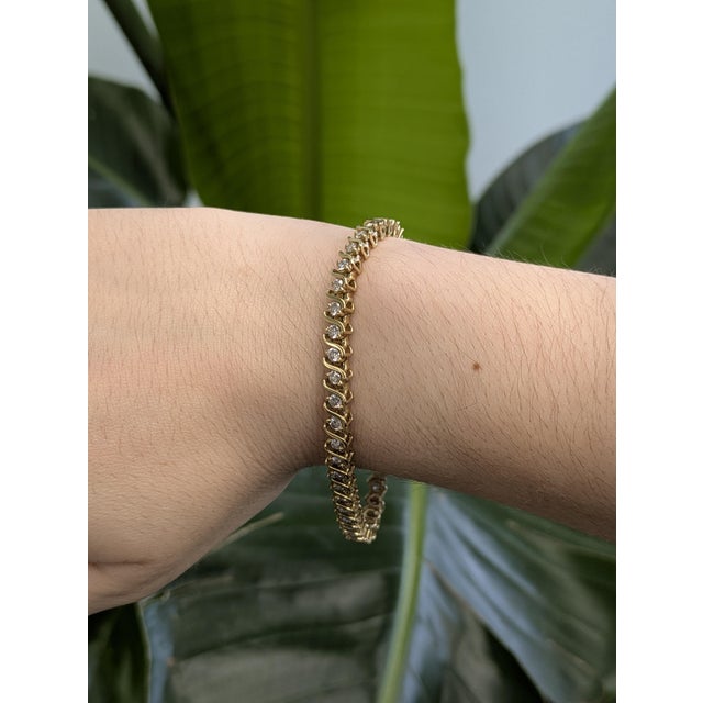 A masterpiece of timeless elegance, this yellow gold Tennis bracelet features a flowing wave design that gracefully frames...