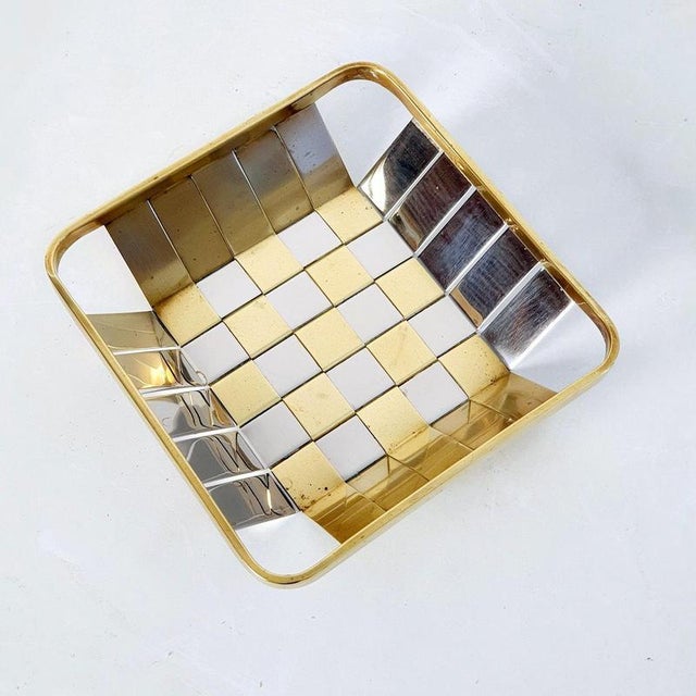 An Italian square basket in silver and gold metal made with weaving technique. This piece is typical for the style of the...