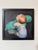 Adrift In The Tide by Fikriye Oz | Oil On Wood Painting of a baby in a green flotation device. For Sale
