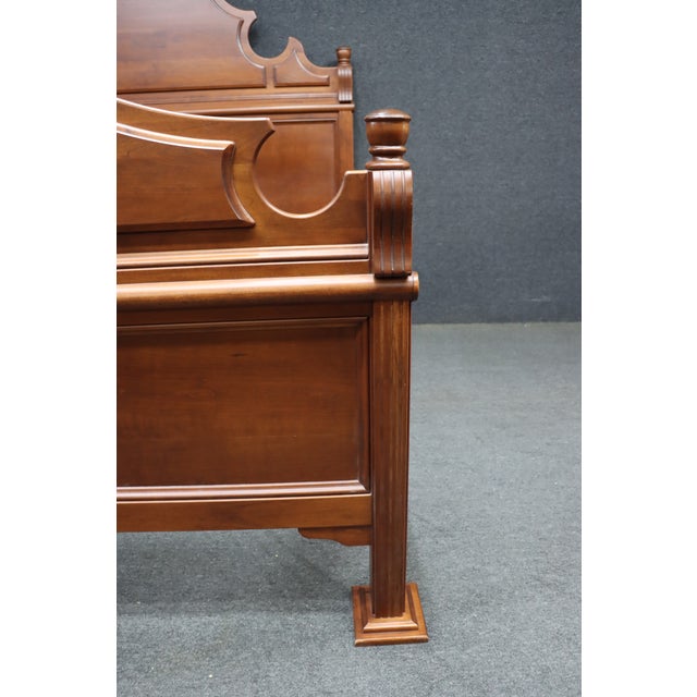 Traditional cherry wood queen-size bed by Dutch Designs, featuring a shaped Federal-inspired headboard with decorative...