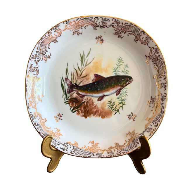 A refined and poetic Limoges porcelain fish service, delicately adorned with hand-painted freshwater fish, each plate...