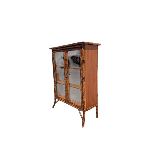 This charming vintage display cabinet in tiger-striped bamboo perfectly embodies the Boho-Chic aesthetic of the late 20th...