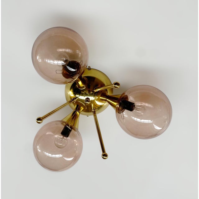 Italian flush mount with three clear coral Murano glass globes mounted on solid brass frame in lacquered polished brass...