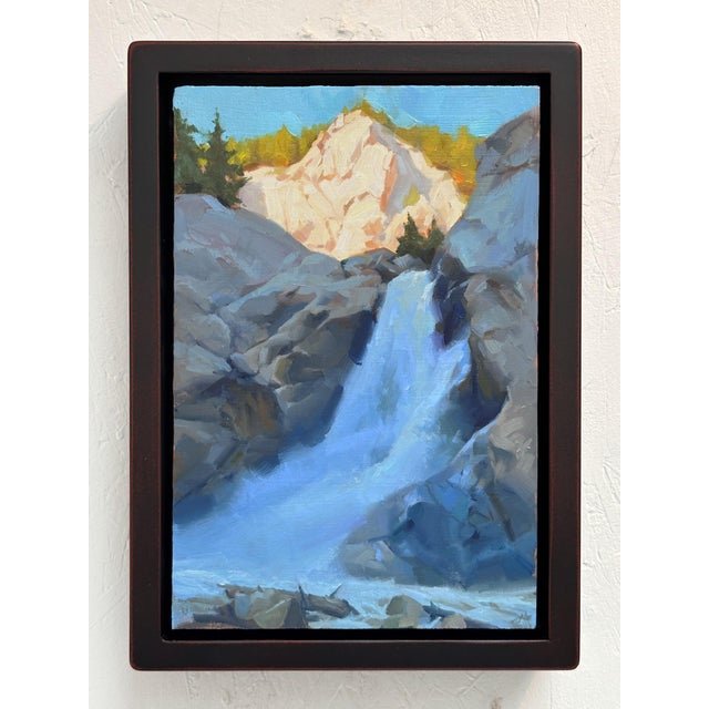 This oil painting on wood panel captures a serene waterfall cascading over rugged rocks, framed by lush trees and distant...
