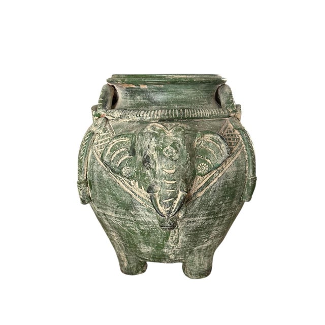 A vintage, pottery elephant vase. Features a squat, rounded pot in the form of an elephant, finished with a weathered,...