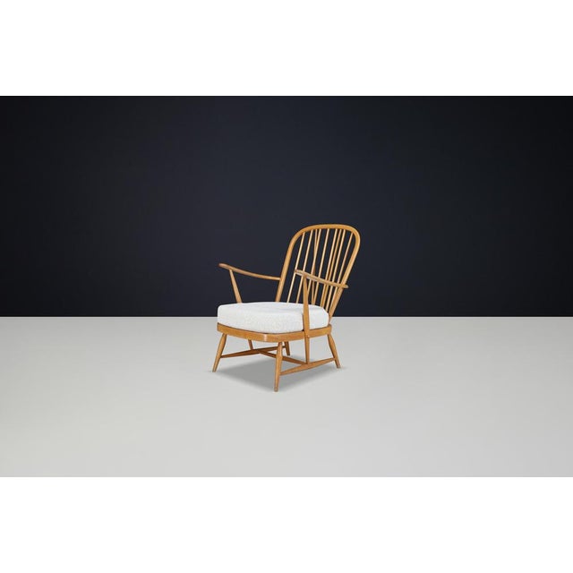 This stunning mid-century Windsor lounge chair by Ercol is a true icon of British design, handcrafted in England during...