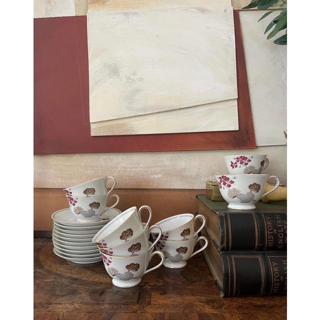 Lovely set of 9 vintage tea, cups, and saucers, made in Japan by Noritake. Presented on a crisp white with a gold rim, a...