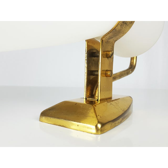 This wall lamp was produced in Italy by Stilnovo in the late 1950s. It is made from a brass structure with a white opaline...