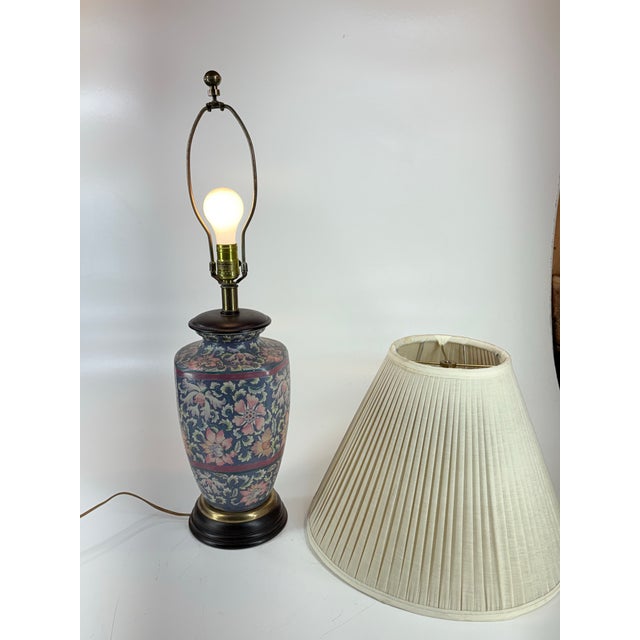 Vintage Chinese porcelain table lamp featuring an eclectic motif in rich hues of Blue, Pink, Turquoise and White. The lamp...