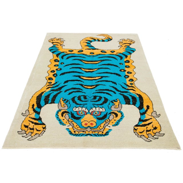 This is a beautiful handmade Turkish Art Deco wool rug with a beige field. It features blue, goldenrod, and black accent...