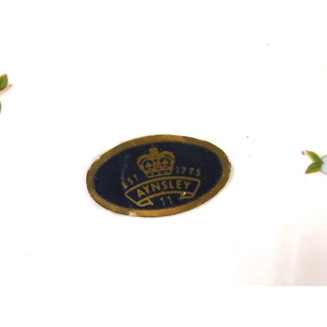 This is a white Aynsley Cake Plate in the Cottage Garden pattern. It is the smaller cake plate or cheese plate and it has...