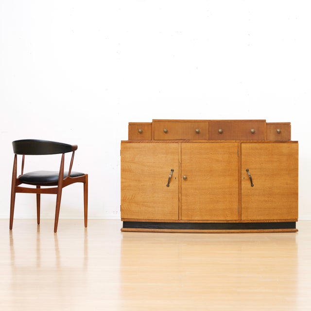 A beautifully crafted English Art Deco oak sideboard dating from the 1930s, featuring a distinctive stepped drawer gallery...