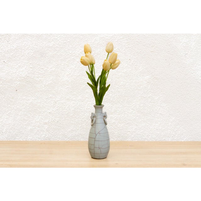 Capture the delicate beauty of ancient Chinese ceramics with this miniature Ge-type crackle vase. Its pale, jade-like...