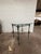 A striking mid-century brutalist side table featuring forged metal designed base with sculptural baluster-form legs and an...