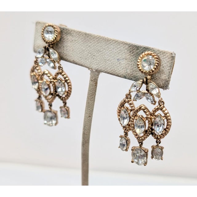 Early 1950s goldtone round and maquise clear rhinestone chandelier clip earrings. Marked crown "TRIFARI." Measures: 1 7/8...