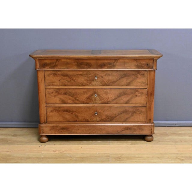 Découvrez cette commode en ronce de merisier, authentique témoignage de l’époque Restauration du début du XIXe siècle....