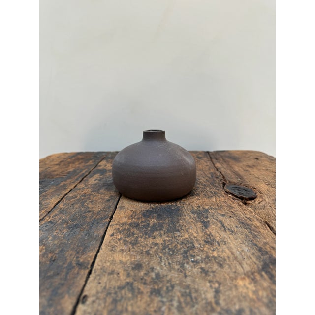 Small bud vase with charming dent in the side. Stamped Pigeon Toe Ceramics on the underside. Dimensions: ~ 4 1/2" Dia ~ 3...