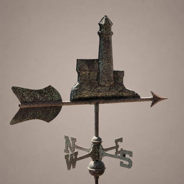 A rare copper weathervane from the early 1900s, featuring a three-dimensional composition depicting a harbor lighthouse....