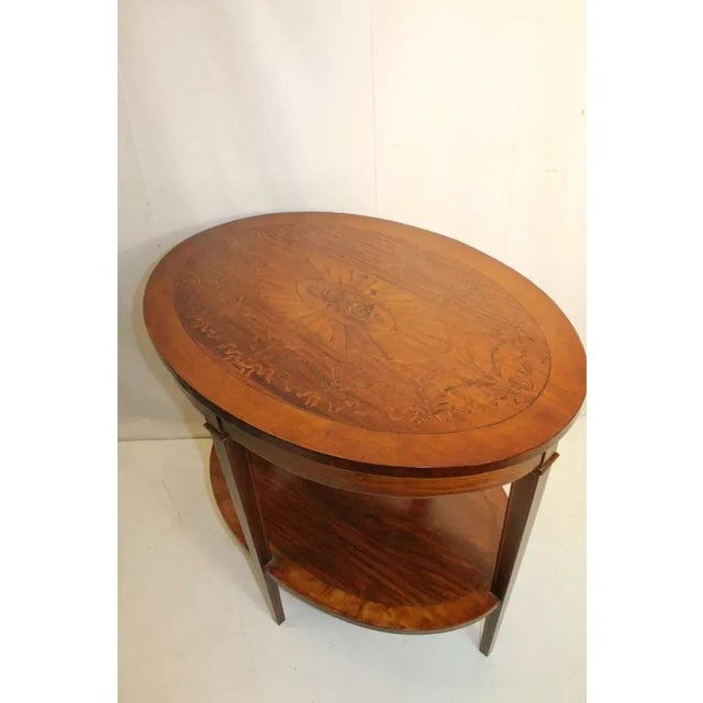 Remarkable Sheraton style inlaid marquetry side end table from the 19th century featuring an oval top surrounded by a...