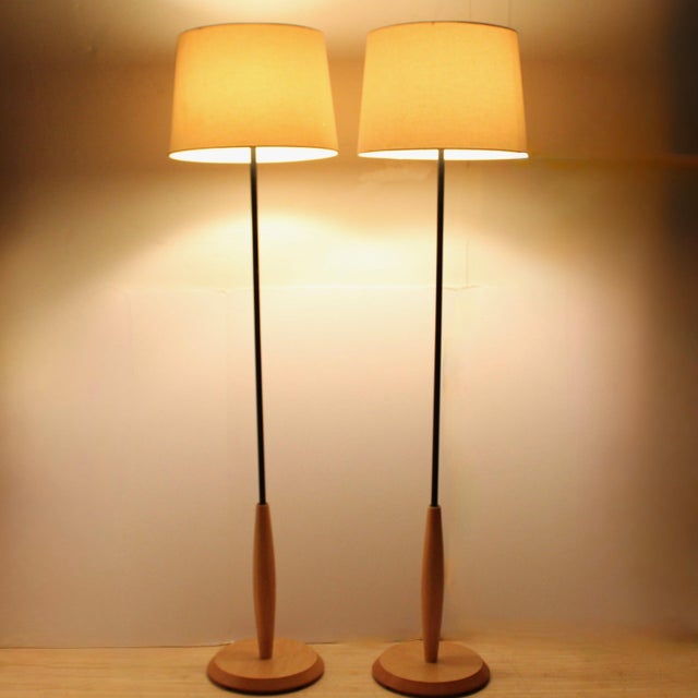 Pair of vintage floor lamps with black metal center post at top and natural beech at the bottom with a solid beech base....