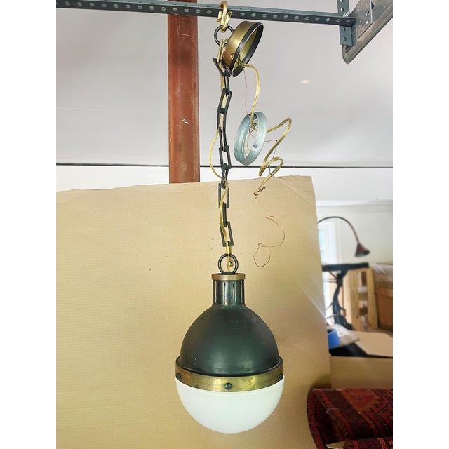 A pair of globe pendant lights designed by interior designer Thomas O'Brien for Visual Comfort & Co. The top parts consist...