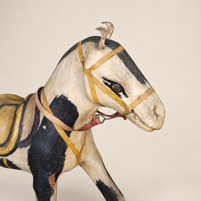 A charming circa 1900 American folk art pull toy horse handcrafted in wood and papier-mâché with its original painted...